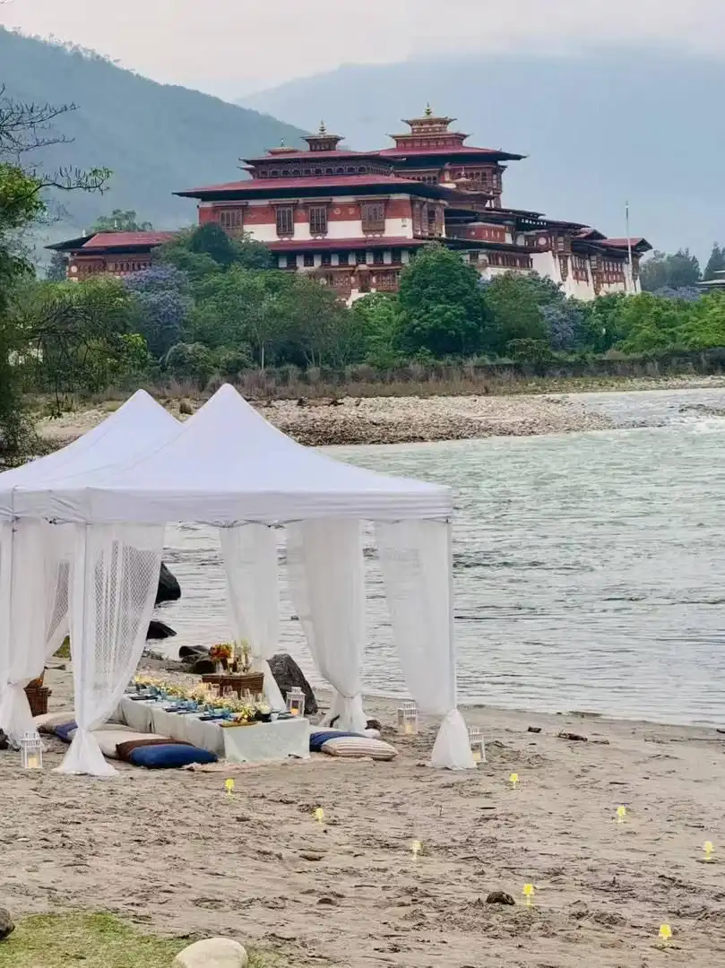 Exclusive riverside dining setup overlooking the majestic Punakha Dzong in Bhutan