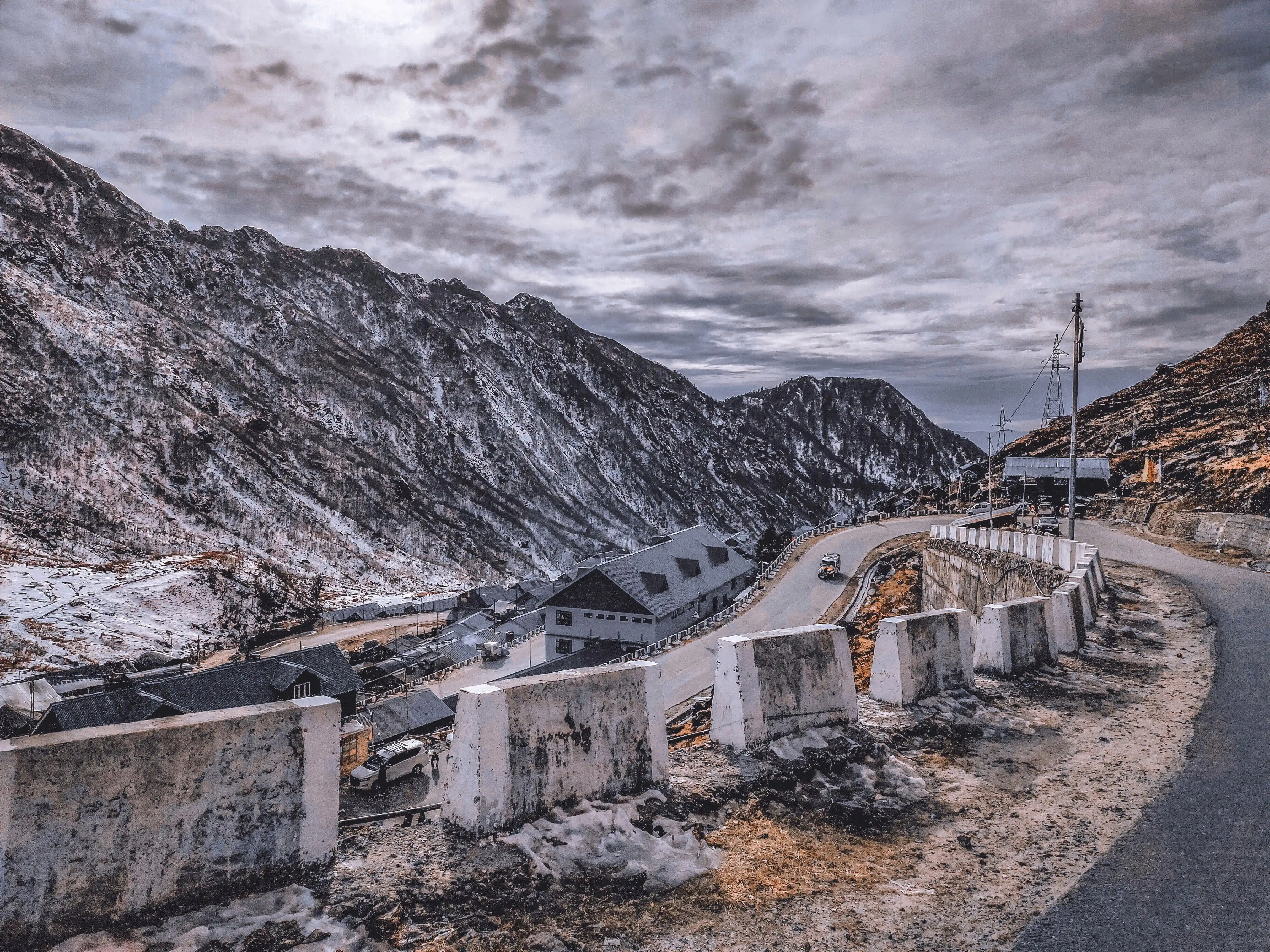 Winding high-altitude mountain road traversing snow-dusted Himalayan peaks in Sikkim